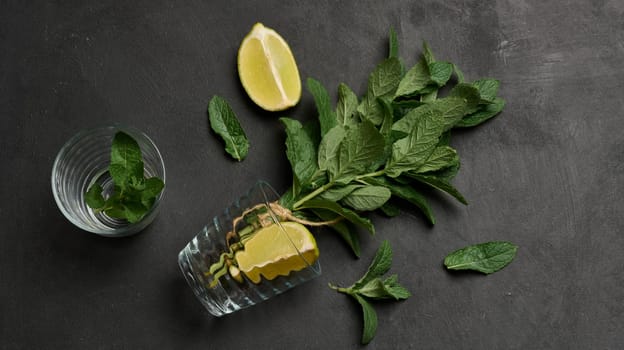 Bunch of fresh green mint, lime slices, glasses, top view. Cocktail ingredient