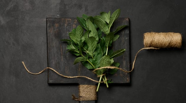 Bunch of fresh green mint on wooden board, top view
