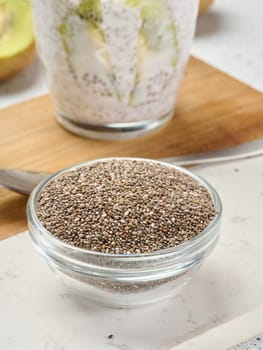 Clear glass bowl filled with dry chia seeds, top view