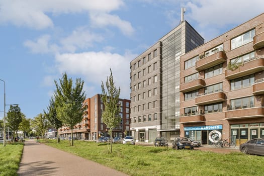 A view showcasing a modern urban landscape featuring contemporary buildings alongside greenery and a paved walkway.
