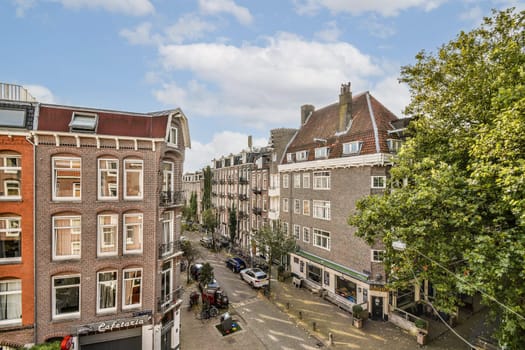 A vibrant view of a street in Amsterdam showcasing historical architecture, lush greenery, and a lively atmosphere. Ideal for travel enthusiasts.