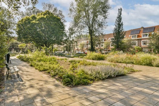 A tranquil park featuring a stone pathway lined with vibrant plants and trees, inviting visitors to enjoy nature's beauty and relax.