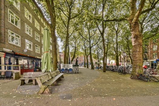 A picturesque urban park scene featuring benches, shaded trees, and cafe seating, perfect for relaxation and social gatherings in the heart of the city.