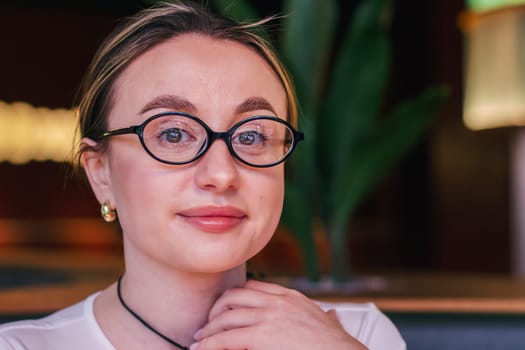 Portrait of a pretty girl in glasses looking at the camera. High quality photo