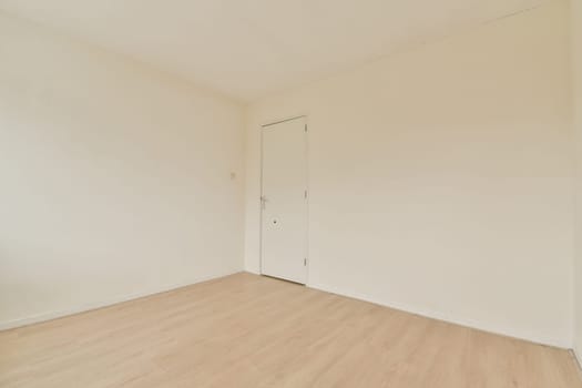 A minimalist interior featuring plain white walls and a light wooden floor, creating a spacious and airy environment perfect for design inspiration.