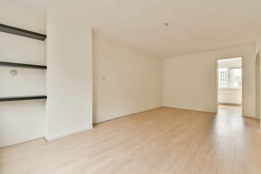 A spacious, empty room featuring light wooden flooring and white walls, creating a clean and minimalist aesthetic. Ideal for interior design inspiration.
