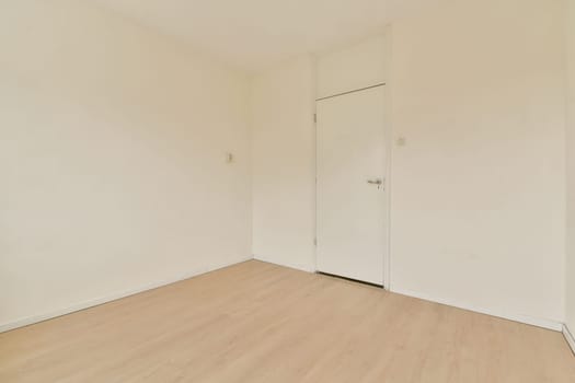 An empty room featuring bare walls and light wooden flooring, showcasing a minimalist aesthetic with ample natural light and simplicity throughout the space.