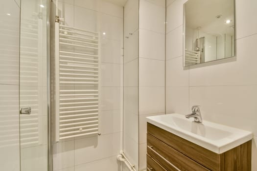 A sleek and contemporary bathroom featuring white tiles and warm wooden accents, enhancing the overall aesthetic appeal and functionality.