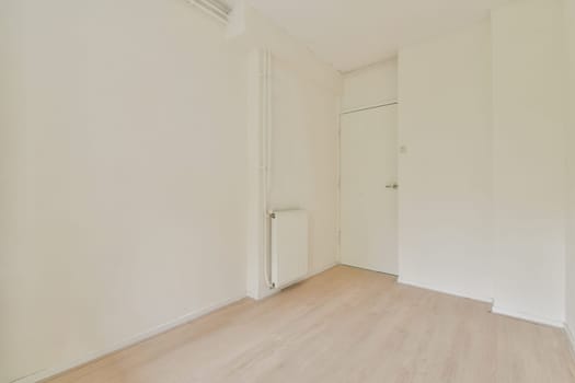 A spacious, minimalist room featuring plain white walls and wooden flooring, exuding simplicity and tranquility. Ideal for modern living concepts.