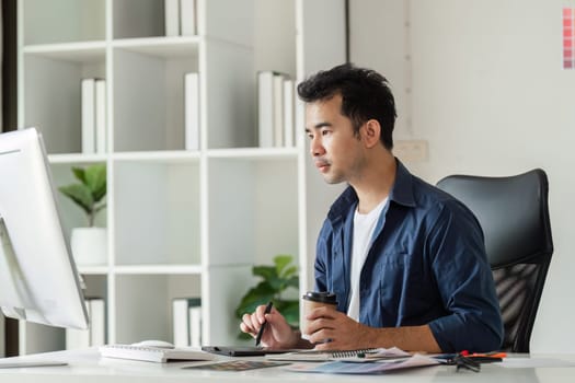 A graphic designer deeply engaged in work at a modern design studio, utilizing digital tools and a creative workspace.
