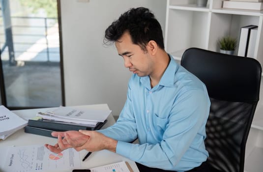 Office worker suffering from muscle aches and pains, highlighting the common issue of office syndrome in modern workspaces.