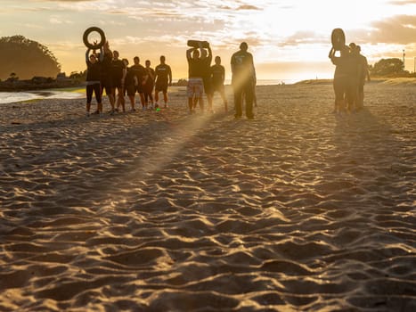 Mount Maunganui New Zealand - November 7 2012; Group of young adults exercising and building fitness in beach boot camp activity on Main Beach.