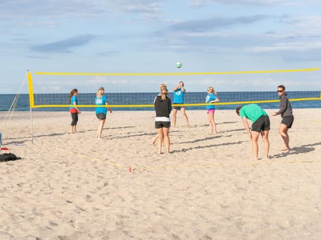Mount Maunganui New Zealand - November 6 2012; Group of young adults playing beach volleyball on Main Beach.