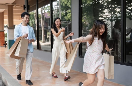 A happy family enjoying a shopping day together, carrying bags and smiling in a modern urban environment.