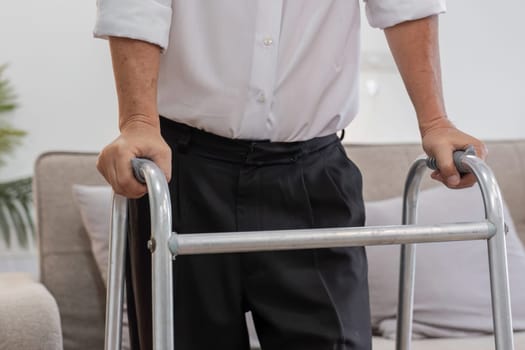 An elderly man uses a cane for support while walking indoors, highlighting independence and mobility in senior life.