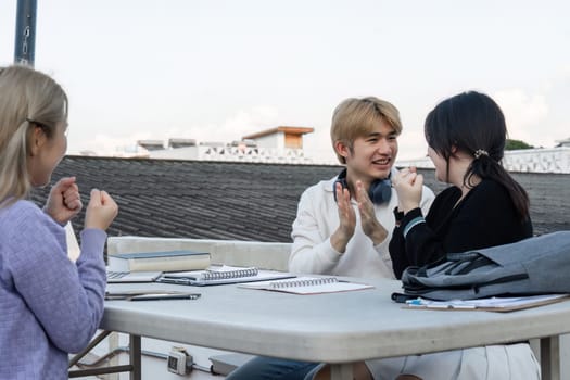 Teenagers gather outdoors to study and collaborate on schoolwork, fostering teamwork and learning.