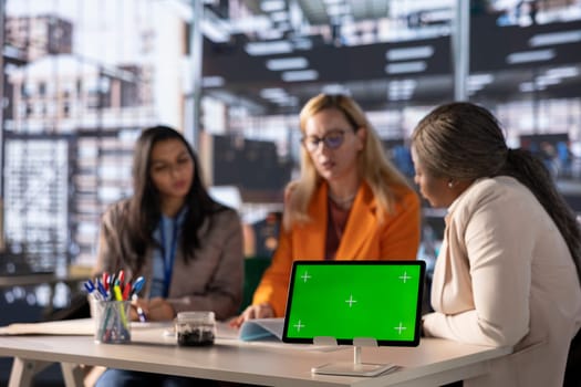 Diverse group of businesswomen strategizing in a professional office with green screen, focused on leadership, empowerment and business growth. Powerful goals oriented employees.