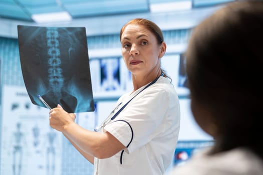 Medical experts meeting in a cabinet to discuss radiography test results, analyze x rays and healthcare records at private clinic. Doctors focusing on diagnostics and disease prevention, teamwork.