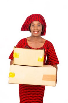 beautiful African delivery woman standing with cardboard boxes, being all smiling. isolated on white background