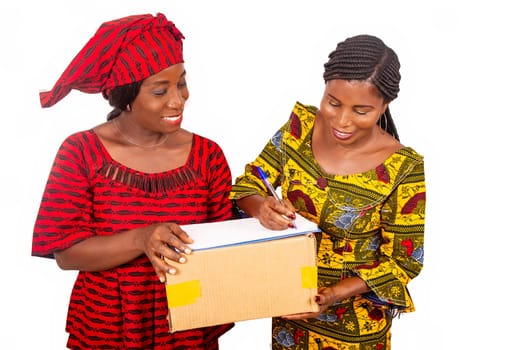 beautiful mature woman messenger carrying a large package and the business woman confirming receipt of delivery by signing