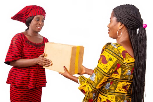 beautiful adult businesswoman smiling while receiving a parcel box from a woman dressed in red loincloth in her office