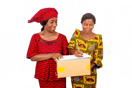 beautiful mature woman carrying a big package while and the businesswoman confirming receipt of delivery by signing it