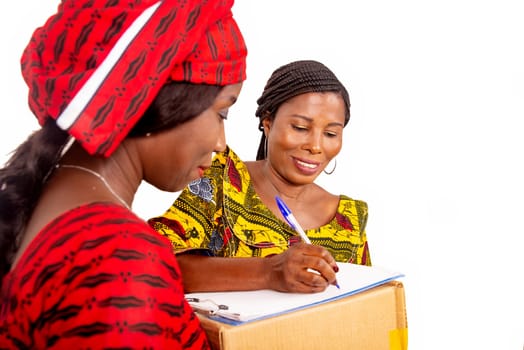 beautiful mature woman messenger carrying a large package while the business woman confirming receipt of delivery by signing