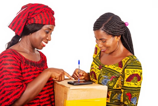 african adult woman client signing her digital mobile phone receiving parcel post office mail box with home delivery service adult woman in red loincloth at home