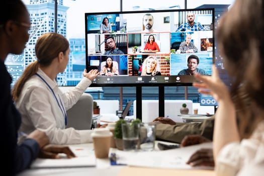 Marketing team analyzing big data insights on online videoconference with the advisory board, creating detailed infographics to present their progress and achieve goals. Remote presentation.