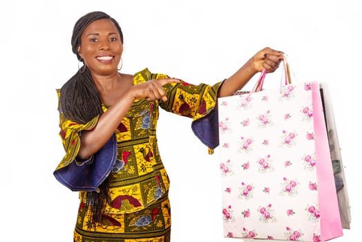 beautiful african mature woman standing pointing at some shopping bag isolated on white background