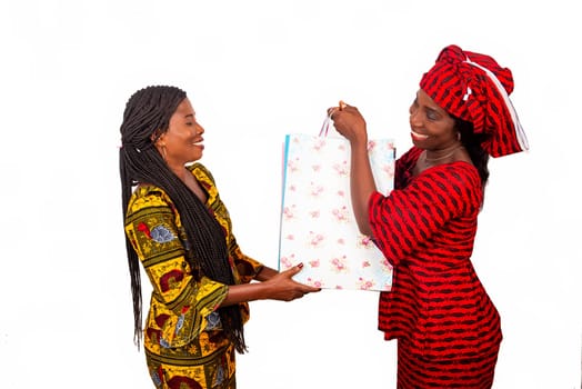 beautiful african adult customer is happy receiving bags from a delivery service of a woman wearing a red loincloth with bags