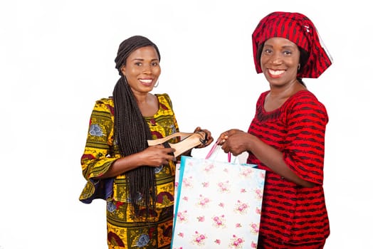 beautiful african adult customer receiving a pair of shoes with home delivery service of a woman wearing a red loincloth with bags