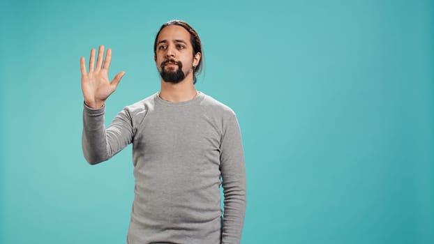 Man looking at AR hologram visualizations, doing swiping gestures. Technology enthusiast using futuristic modern augmented reality tech, isolated over studio background, camera B