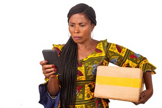 beautiful adult woman is pissed off looking at cellphone while holding a cardboard while smiling