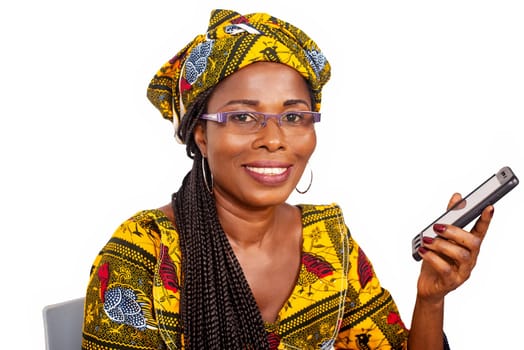 beautiful african adult woman sitting on a chair is smiling while holding a mobile phone