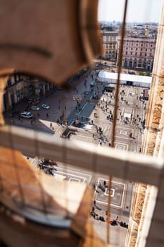 Milan, Italy - 19.03.2024: Aerial view of busy urban square with pedestrians and historic architecture, Milan Duomo Cathedral.