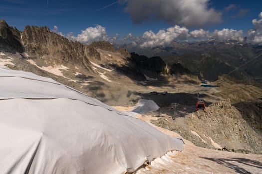 Passo Tonale, Italy - 10.08.2024: Majestic mountain landscape with ski lift and snow-covered peaks.