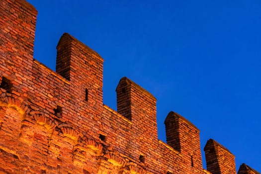 Gradara, Italy - August, 25, 2022: illuminated gradara castle walls with vibrant dusk sky