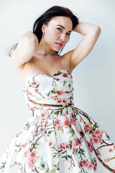 Portrait of a beautiful gentle brunette woman in a dress with flowers