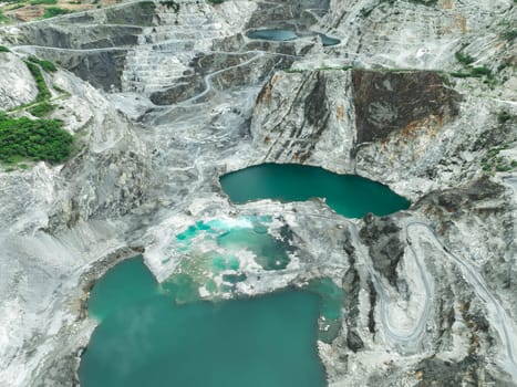 Open pit mine industry. Limestone quarry with backhoe and truck in operation. Heavy machinery in mining industry and construction material supply. Landscape of resource extraction in a industrial site
