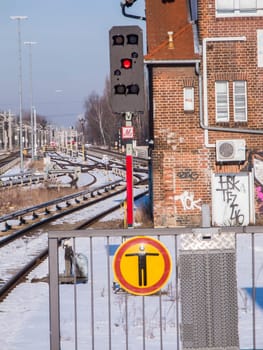 Berlin, Deutschland - Februar 20, 2025: Absperrung am Ende eines Bahnsteigs mit Piktogramm, Gleisanlagen und rotem Ausfahrsignal.