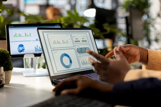 Business analyst meeting with a coworker to review financial report, leading a briefing presentation and exchanging ideas on enterprise development. Achieving goals for expansion.