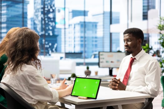 Employers using isolated screen tablet to find qualified candidates through job postings, using recruiting tools. HR coworkers using chroma key device to identify employees to get hired for company