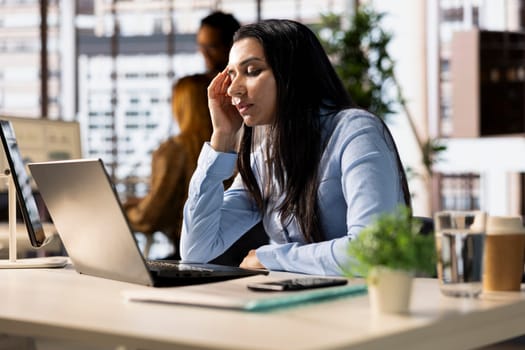Corporate indian woman experiences business pressure at the office, overwhelmed by administrative tasks and deadlines. Manager with frustration dealing with fatigue and low energy.