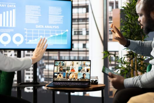 Managers waving hand, chatting with collaborators working from home, holding videoconference meeting using laptop to present new project. Supervisors saluting workers in remote videocall