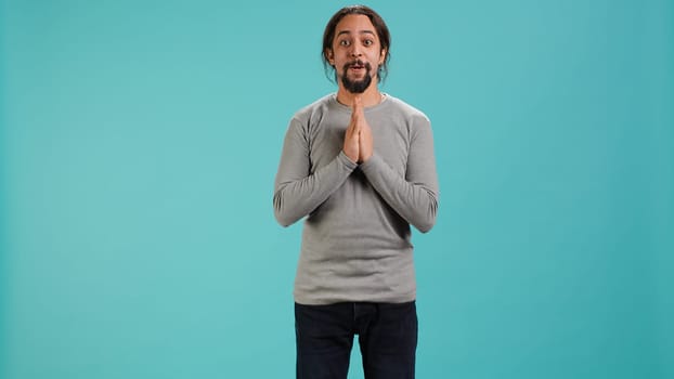 Chipper joyful man happily clapping hands, eager to receive good news. Excited person cheering, applauding, feeling hopeful and keen, isolated over studio background, camera A