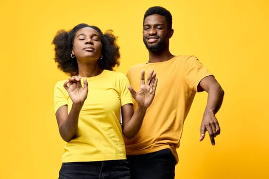 An African American couple enjoying a carefree dance in matching yellow T shirts, set against a bold yellow backdrop This image captures joy, energy, and vibrancy, ideal for lifestyle and positivity