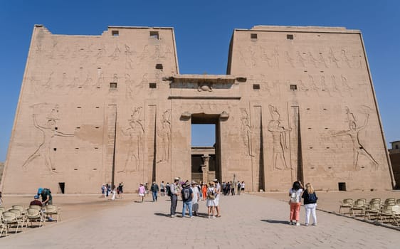 Edfu, Egypt - 6 November 2024: Many tourists looking at the facade of the massive temple in Edfu dedicated to Horus and Hathor
