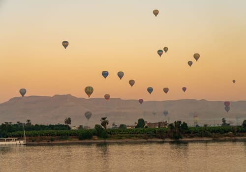 Many balloons in the sky over Nile River in Luxor for sunset flight over the Valley of the Kings