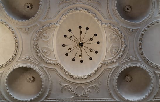 Royal Tunbridge Wells, UK - Apr 29, 2025 - Look up at A stunning chandelier hanging on The ceilings are made of plaster is carved into a dome shape interior of The Church of King Charles the Martyr. use it as your Wallpaper, Poster and Copy space, Selective focus.